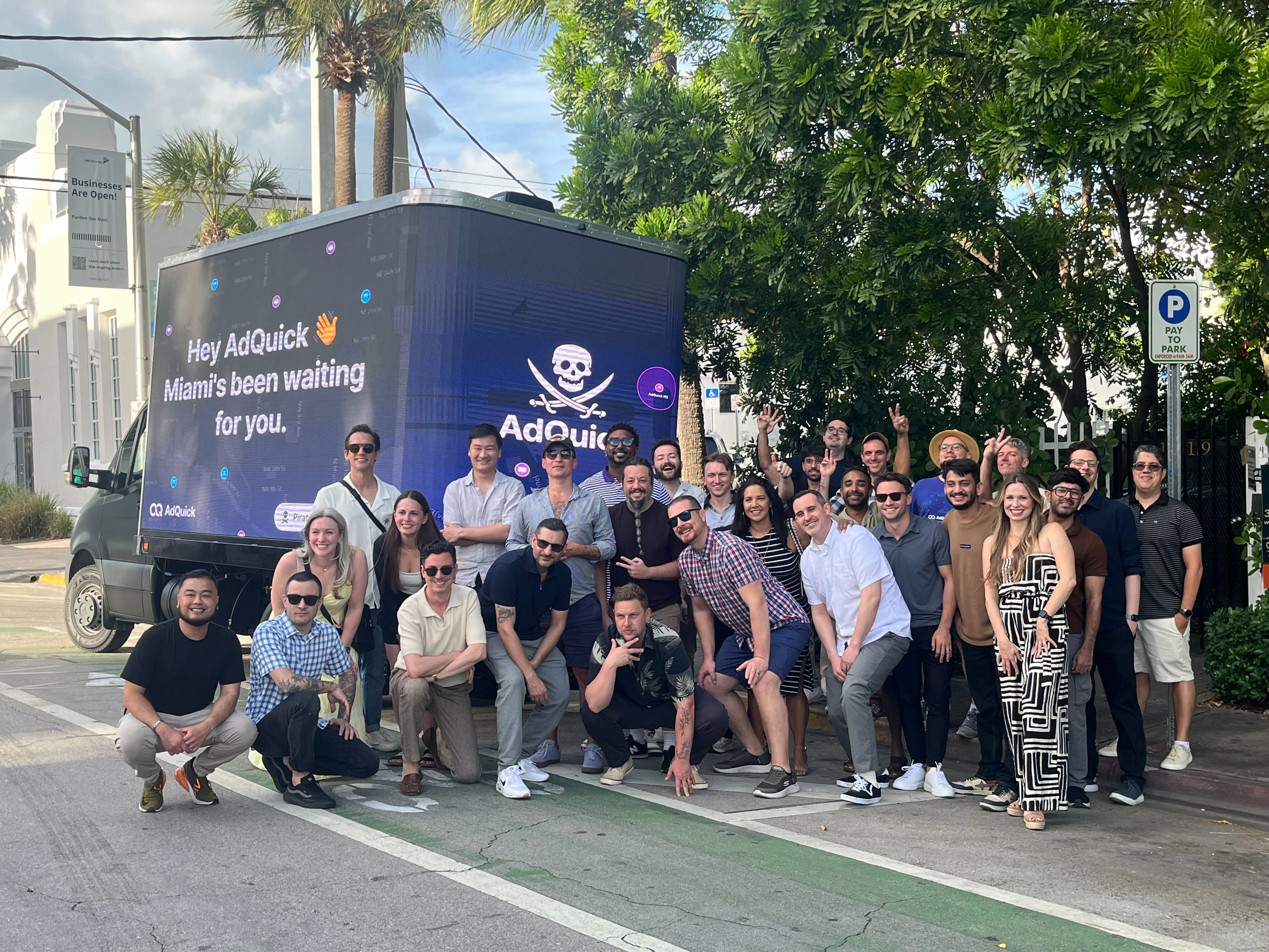 The AdQuick team gathered in Miami in front of a digital billboard truck reading Hey AdQuick, Miami's been waiting for you.